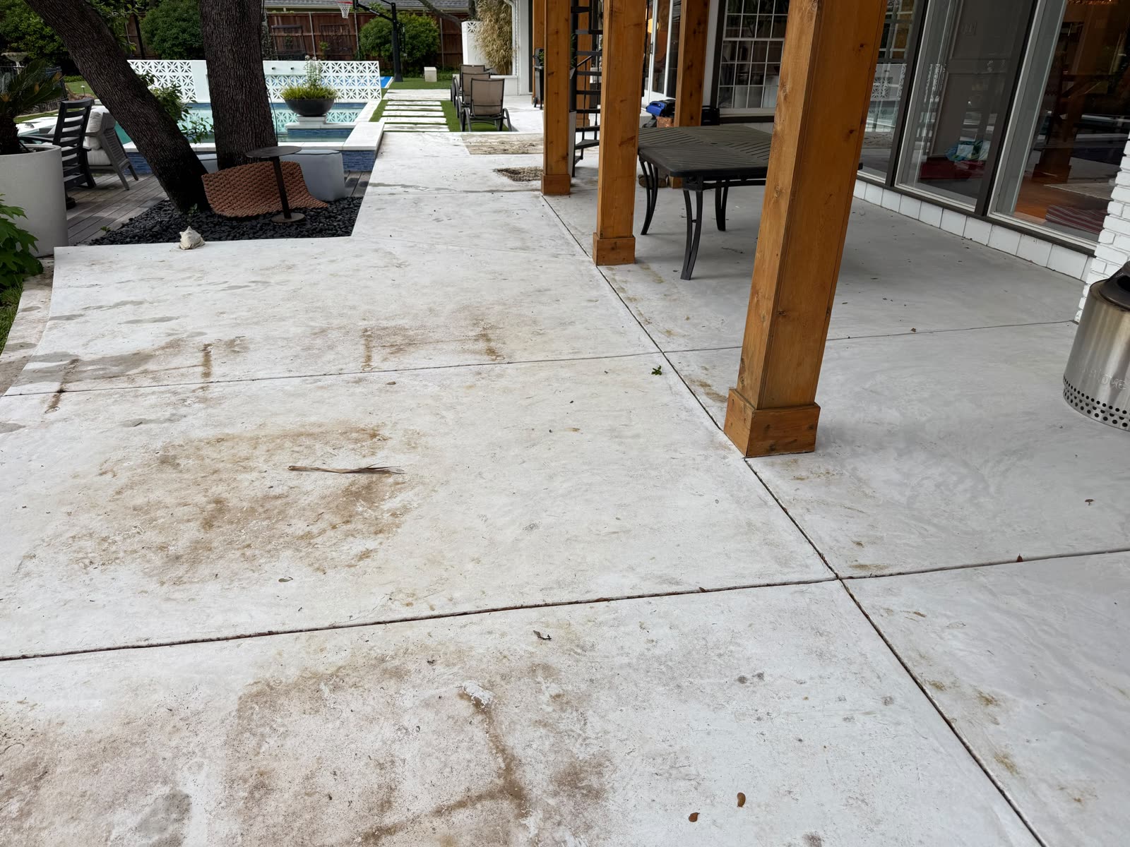 Covered patio concrete stained before pressure washing