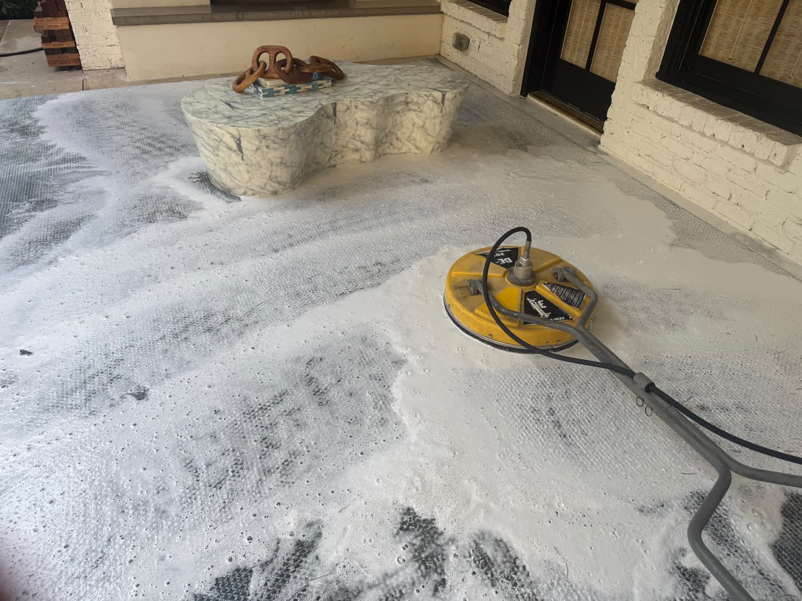Pressure washing equipment in use on a residential patio